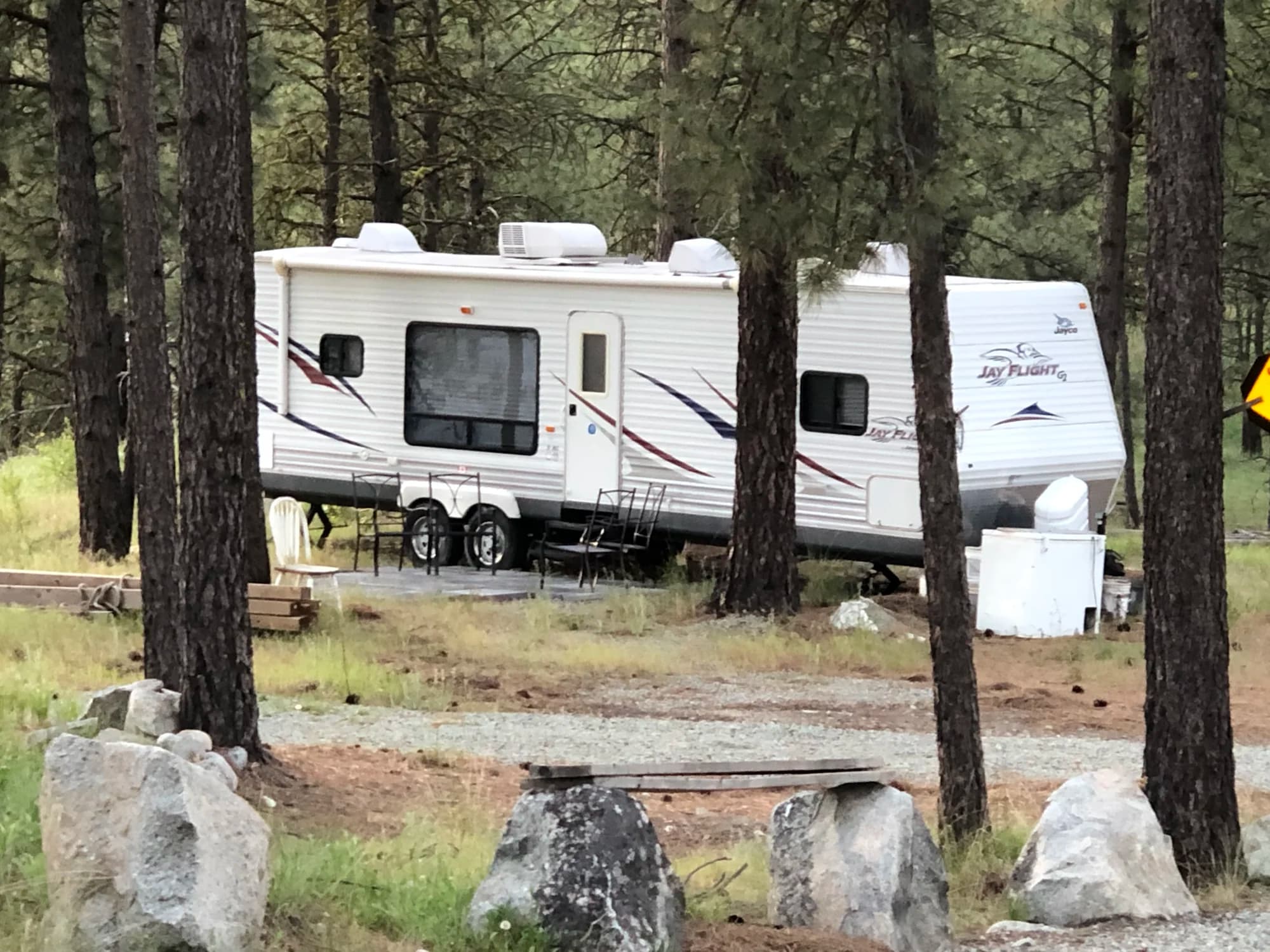 Jay Flight RV motorhome parked among pine trees on Vista Peak property
