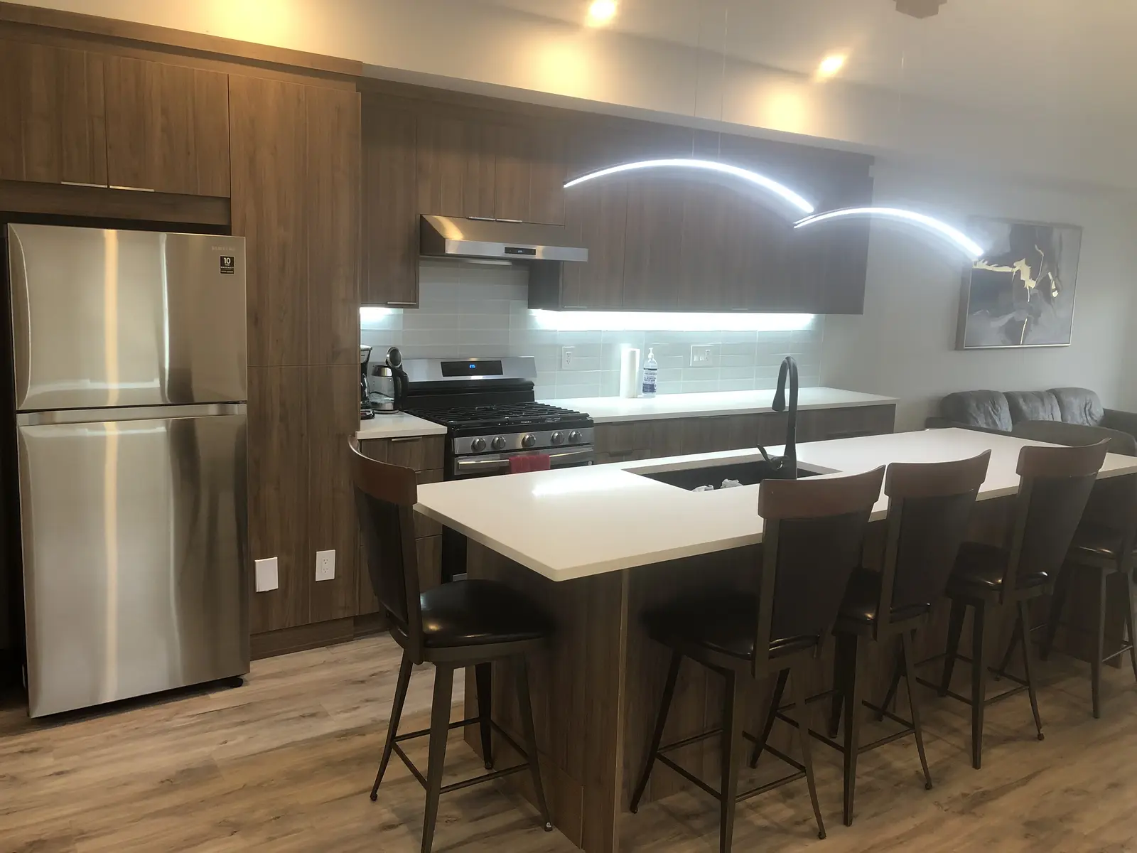 Aisha's Jewel kitchen with white cabinets, modern appliances and oversized island