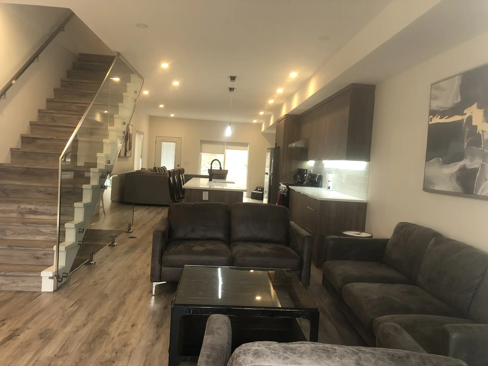 Wide angle view of Aisha's Jewel open concept main floor with family room and kitchen