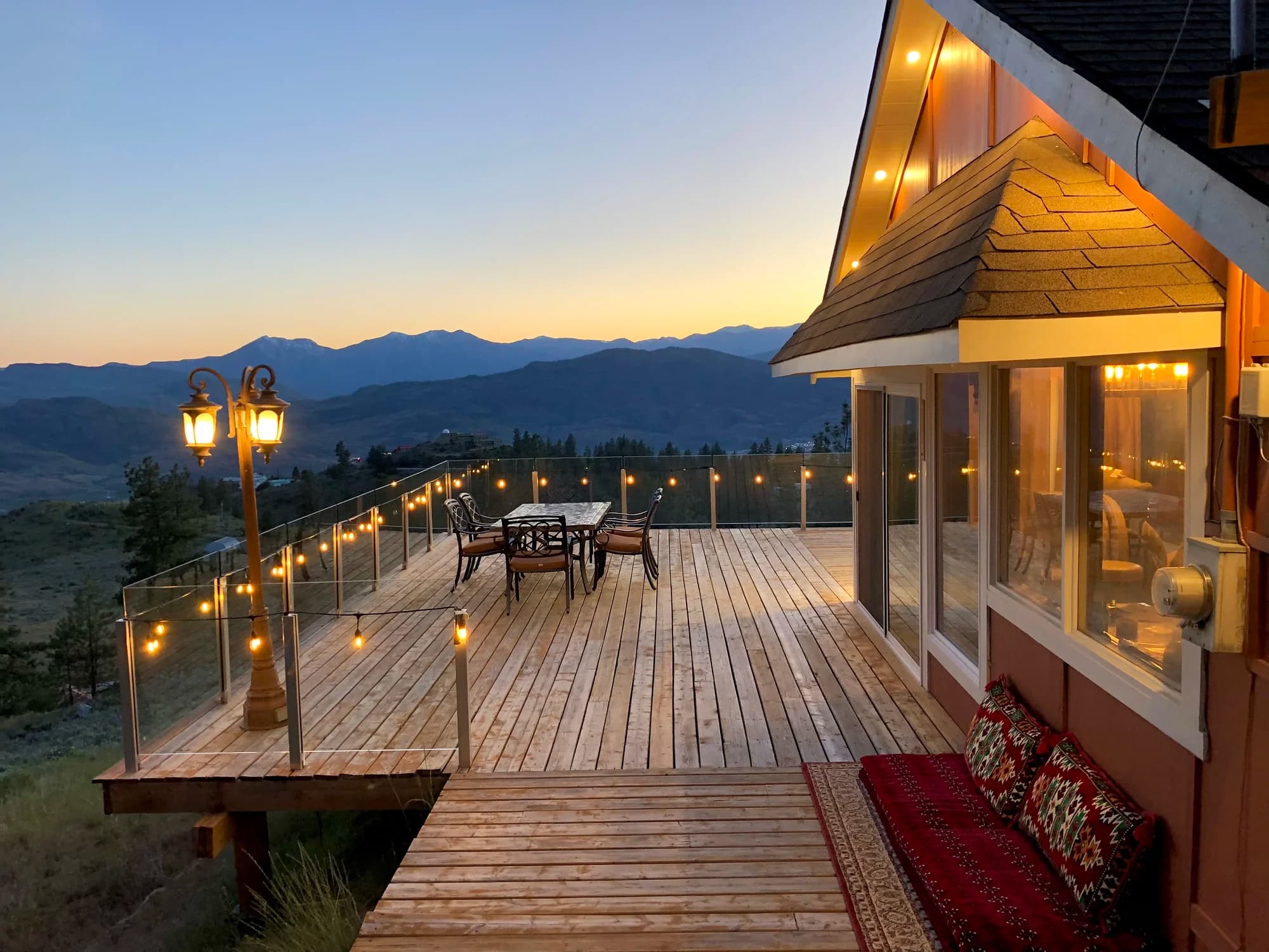 Summit Retreat deck at sunset with string lights and mountain views