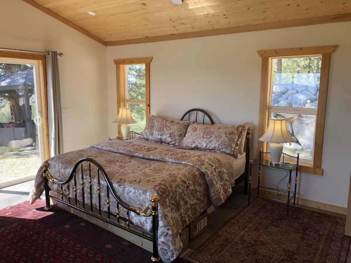 Vista Peak bedroom 2 with queen bed, metal frame, knotty pine ceiling and three windows
