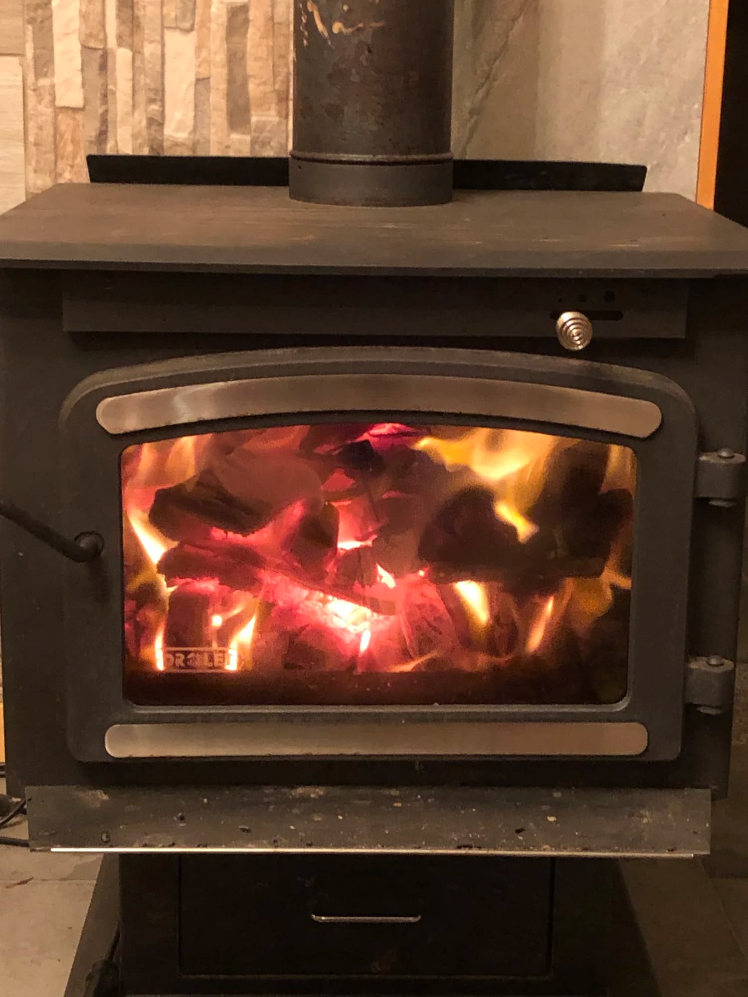 Active wood burning stove with glowing coals in Summit Retreat living room